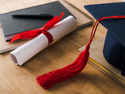 Image of a diploma and a cap